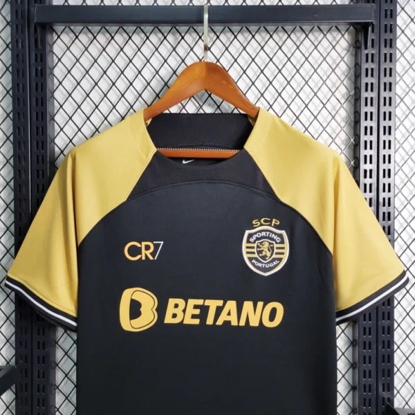 efmwõfopw Camisa Sporting Third Versão Torcedor CR7 2023/24 Dourada - Imagem 3