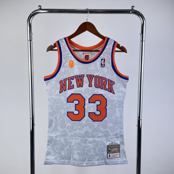 e3edd853 Camiseta Regata NBA New York Knicks BAPE 33 Patrick Ewing Mitchell & Ness Branca 1991/92 - Imagem 1